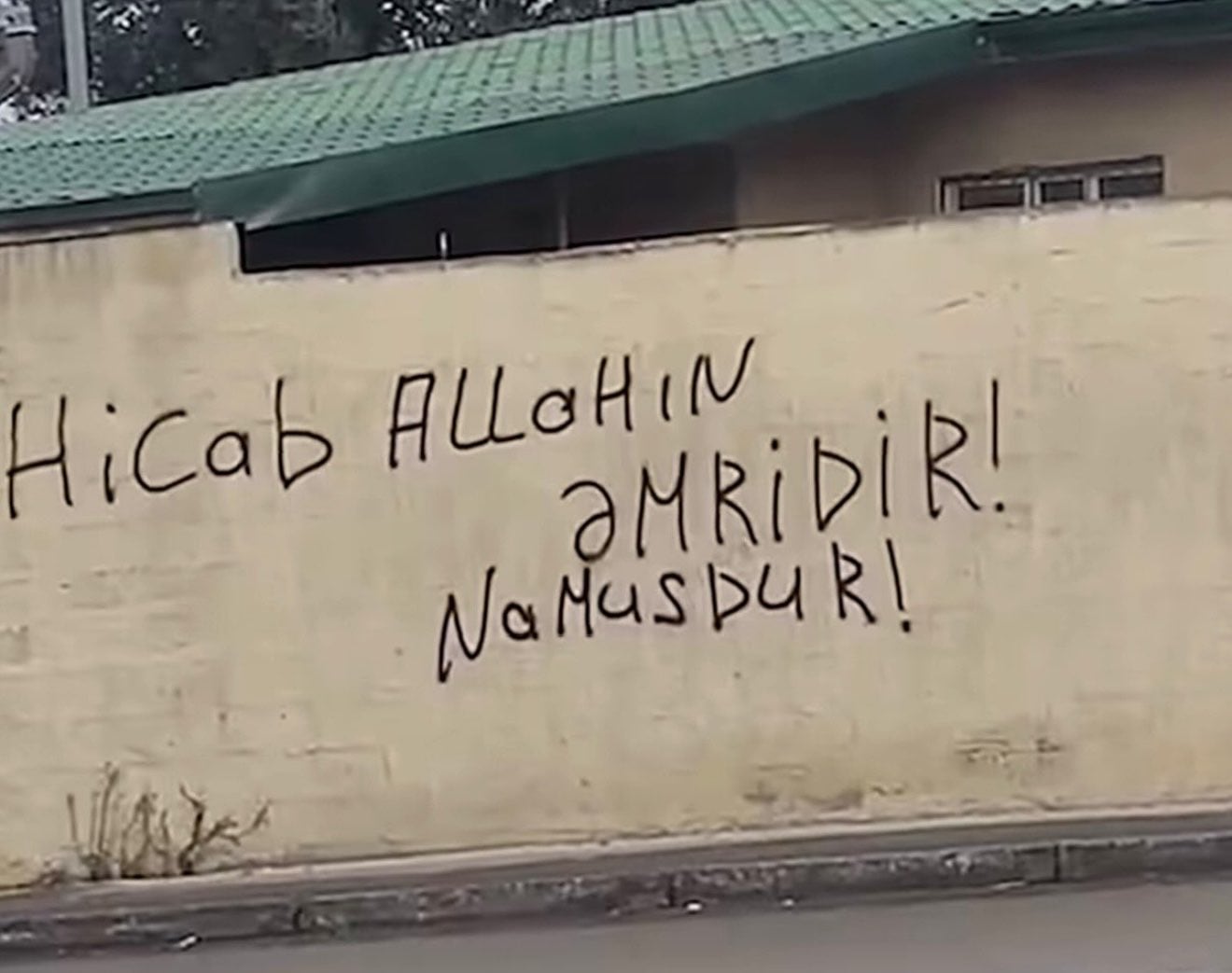 Divara əl ilə yazılmış yazı: “Hicab Allahın əmridir, namusdur!”